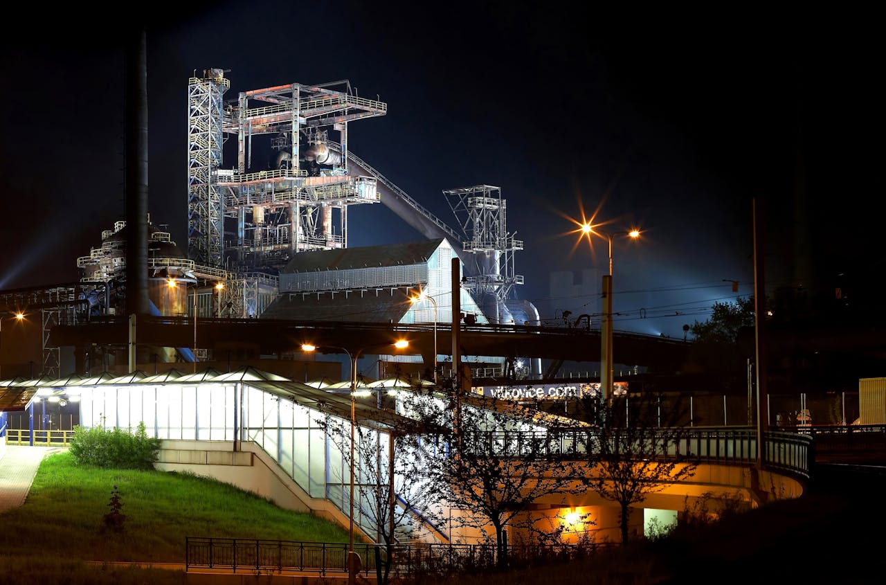 A beautifully illuminated industrial plant with steel structures shining against the night sky.